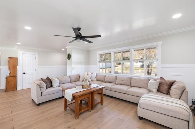 living area with light wood finished floors, a wainscoted wall, ceiling fan, crown molding, and recessed lighting