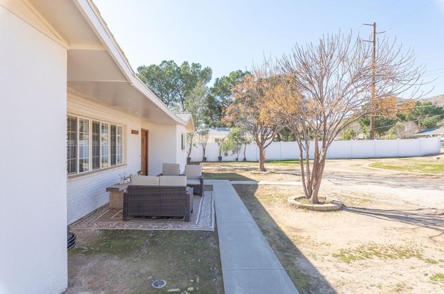 view of yard featuring fence, outdoor lounge area, and a patio