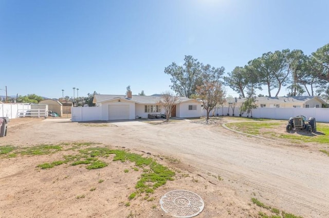 ranch-style house featuring driveway, an attached garage, and fence