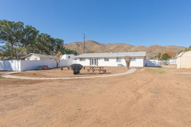 rear view of house featuring a patio area, a mountain view, and fence