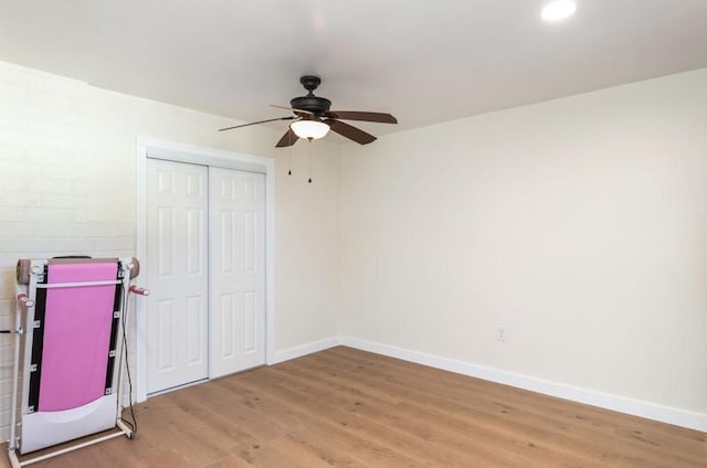 unfurnished bedroom with light wood finished floors, a ceiling fan, baseboards, and a closet