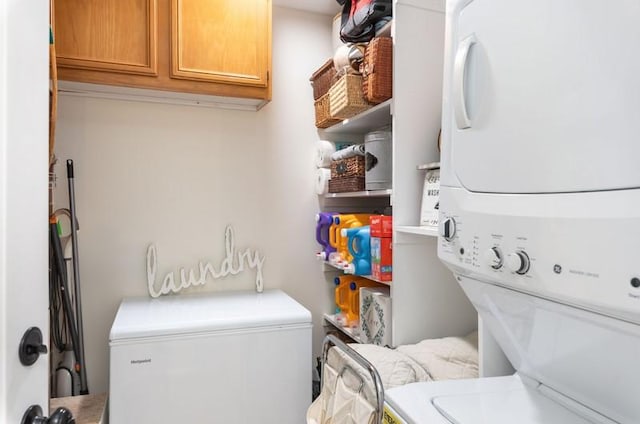 washroom with cabinet space and stacked washer and clothes dryer