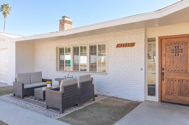 property entrance with an outdoor hangout area, brick siding, and a chimney