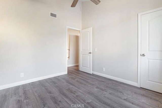 unfurnished bedroom with a ceiling fan, baseboards, visible vents, and wood finished floors