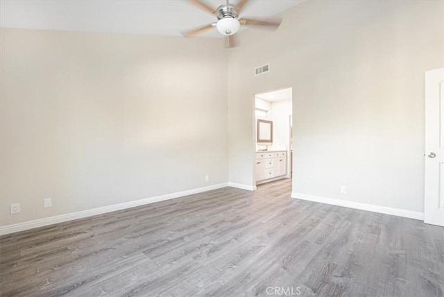 interior space with visible vents, a ceiling fan, high vaulted ceiling, light wood-type flooring, and baseboards