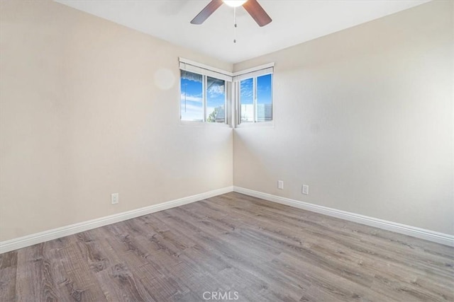 unfurnished room with light wood-style floors, a ceiling fan, and baseboards