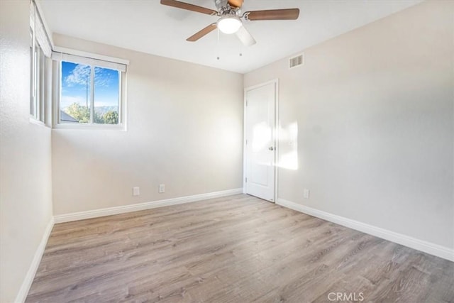 unfurnished room featuring a ceiling fan, light wood-type flooring, visible vents, and baseboards