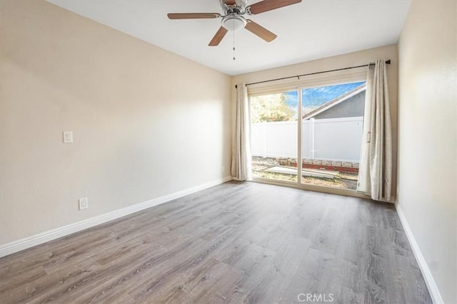 unfurnished room featuring ceiling fan, baseboards, and wood finished floors