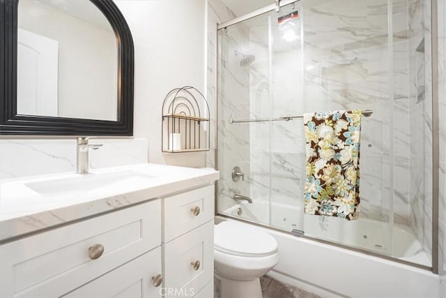 full bathroom featuring combined bath / shower with glass door, vanity, and toilet