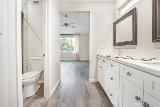 full bathroom featuring double vanity, baseboards, visible vents, toilet, and wood finished floors