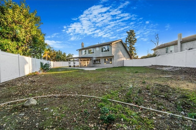 back of property with a patio area, a fenced backyard, and a chimney