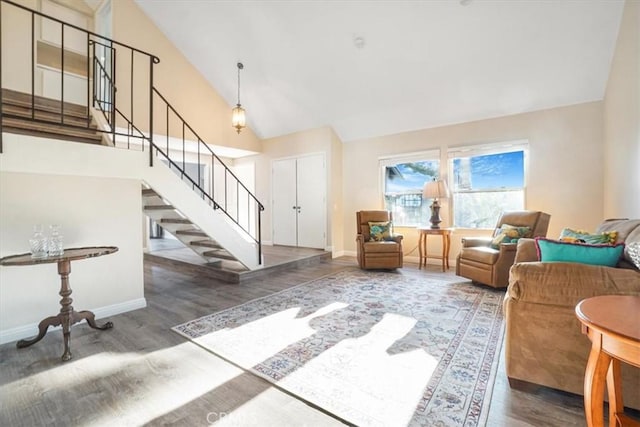 interior space featuring high vaulted ceiling, dark wood finished floors, stairway, and baseboards