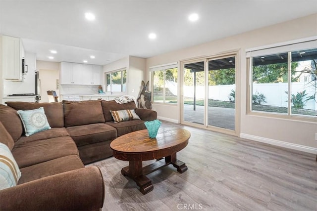 living room featuring recessed lighting, light wood-style flooring, and baseboards