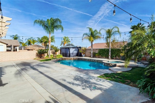 view of swimming pool featuring a fenced backyard, a pool with connected hot tub, a patio, and a gazebo