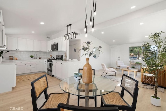 dining room with vaulted ceiling with beams, light wood finished floors, and recessed lighting