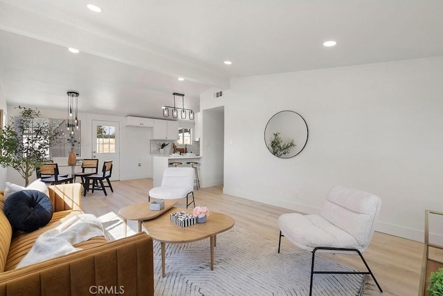 living room with recessed lighting, vaulted ceiling with beams, light wood-style flooring, and baseboards