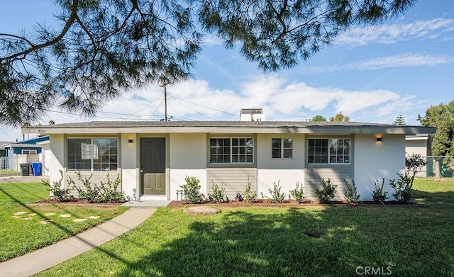 ranch-style house featuring a front yard and stucco siding