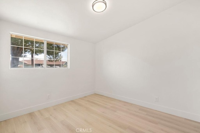 spare room with light wood-style floors and baseboards