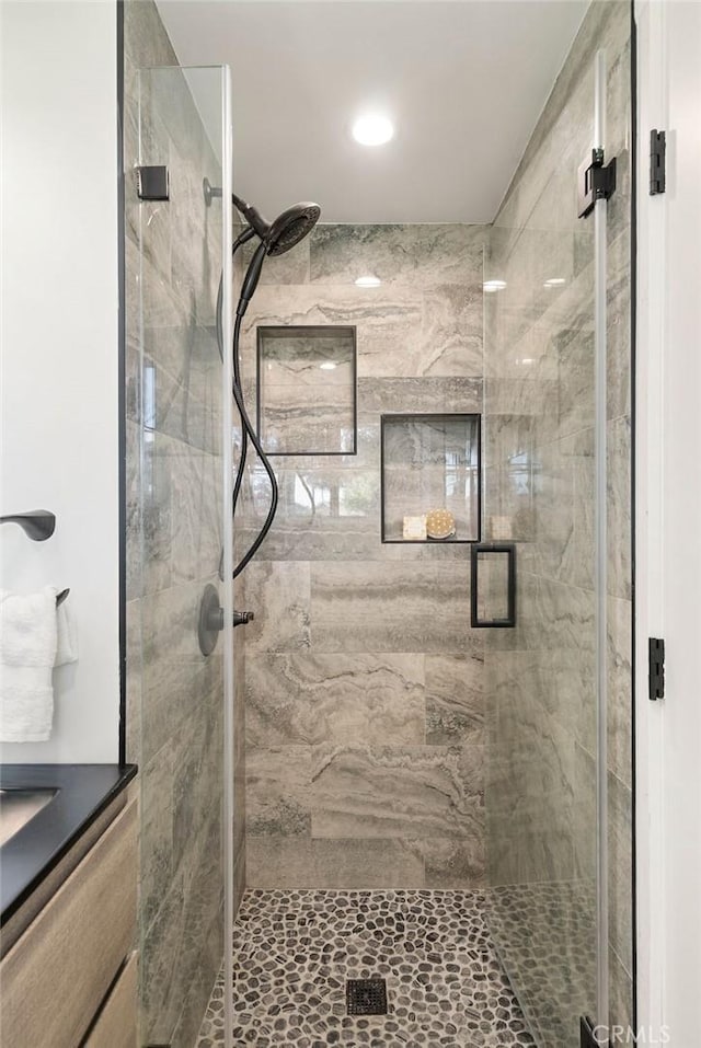 bathroom with a stall shower and vanity