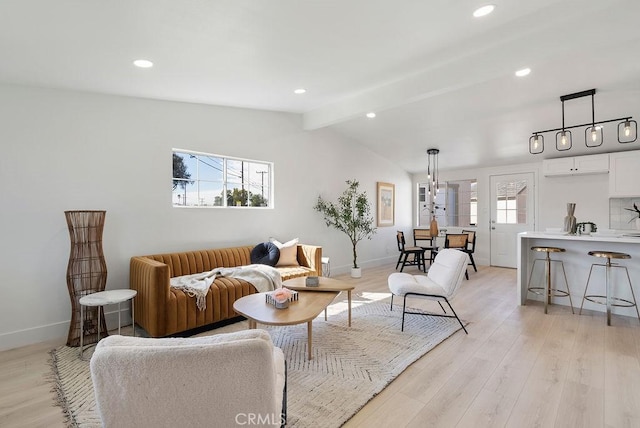 living room featuring lofted ceiling with beams, light wood finished floors, plenty of natural light, and baseboards