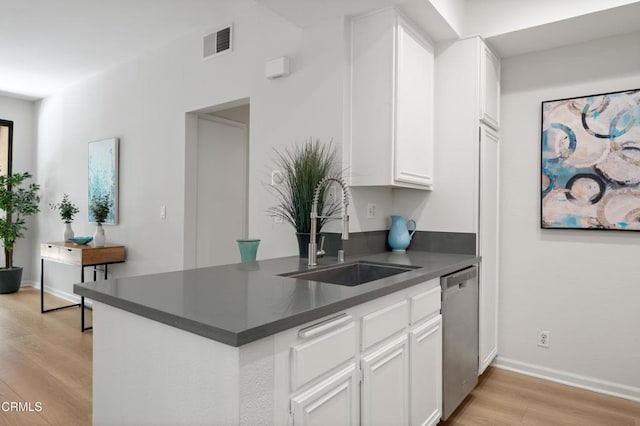 4200 Via Arbolada Unit 207, Los Angeles, CA 90042 - kitchen featuring stainless steel dishwasher, dark countertops, light wood-style floors, and white cabinets