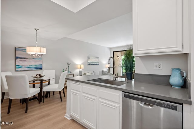 4200 Via Arbolada Unit 207, Los Angeles, CA 90042 - kitchen with dishwasher, dark countertops, white cabinetry, light wood-style flooring, and hanging light fixtures