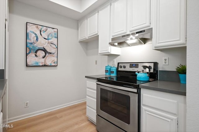 4200 Via Arbolada Unit 207, Los Angeles, CA 90042 - kitchen featuring under cabinet range hood, stainless steel electric range, dark countertops, light wood-type flooring, and white cabinets