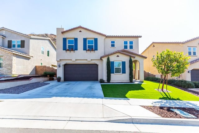 mediterranean / spanish house with driveway, a tile roof, an attached garage, a front yard, and stucco siding