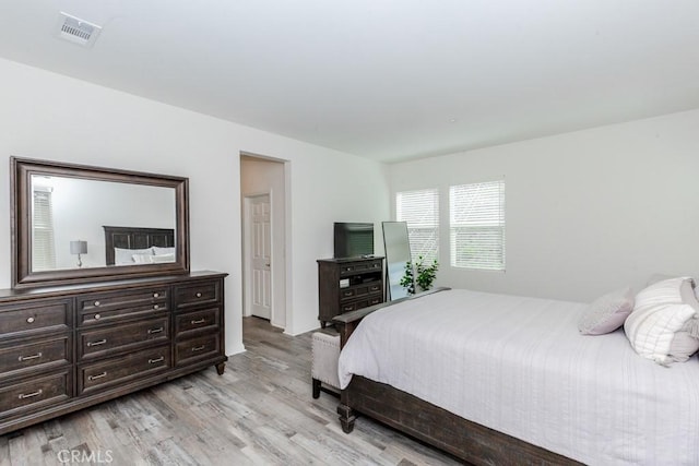 bedroom with light wood finished floors and visible vents