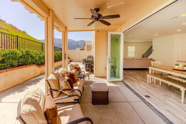 view of patio / terrace with ceiling fan, fence, a mountain view, and an outdoor hangout area