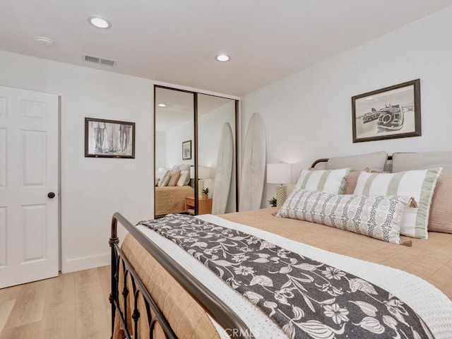 bedroom featuring light wood-style flooring, recessed lighting, visible vents, baseboards, and a closet