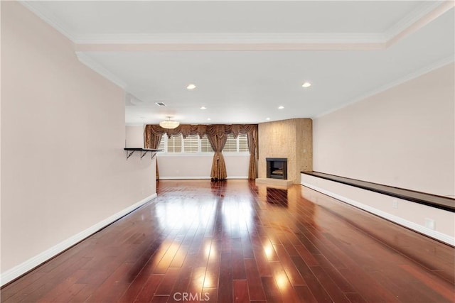 unfurnished living room featuring recessed lighting, dark wood-style flooring, a fireplace, baseboards, and ornamental molding