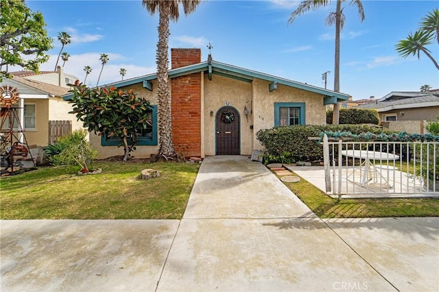 mid-century home featuring fence, a chimney, a front lawn, and stucco siding