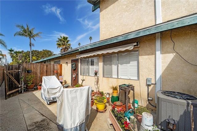 view of patio / terrace with a gate, fence, and central AC unit