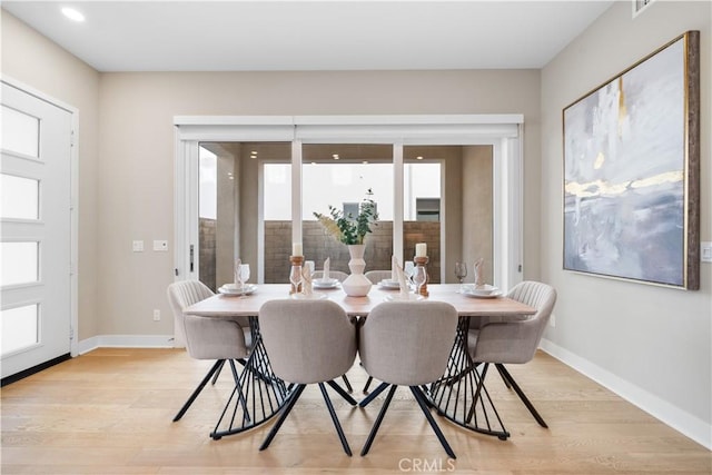 dining room featuring light wood-style floors and baseboards