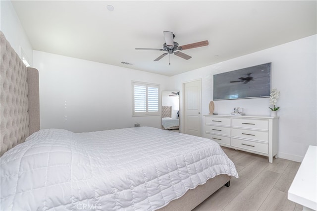 bedroom featuring ceiling fan, baseboards, visible vents, and light wood-style floors