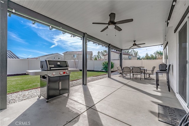 view of patio featuring ceiling fan, a grill, outdoor dining area, and a fenced backyard