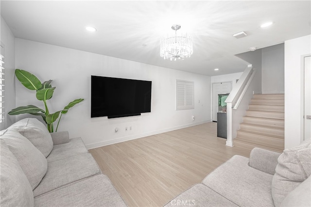 living room with light wood-style flooring, stairway, a chandelier, and baseboards