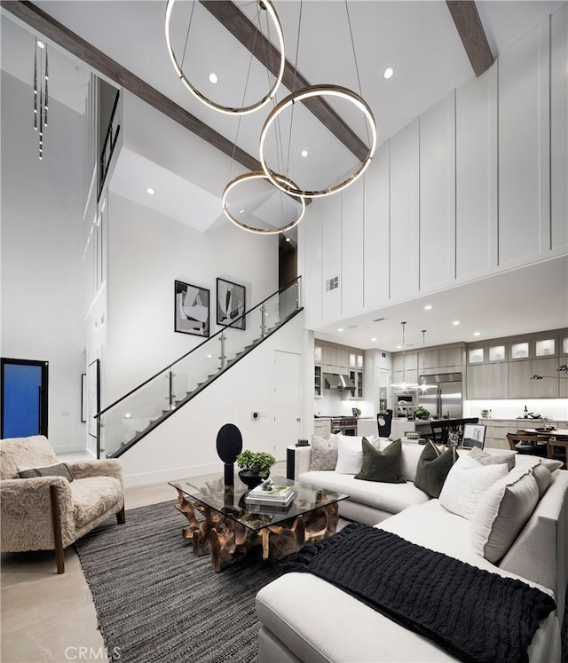 living room featuring recessed lighting, beamed ceiling, a high ceiling, and stairs