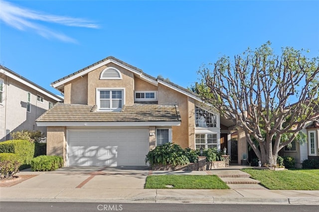 traditional-style house with an attached garage, a tiled roof, concrete driveway, and stucco siding