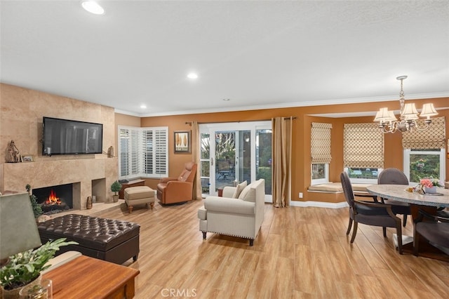 living area featuring ornamental molding, recessed lighting, light wood-style flooring, and a premium fireplace