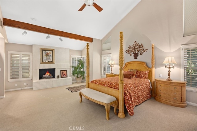 carpeted bedroom with baseboards, ceiling fan, beamed ceiling, a fireplace, and high vaulted ceiling