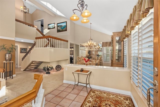 interior space with a chandelier, high vaulted ceiling, light carpet, baseboards, and stairs