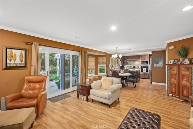 living area featuring ornamental molding, a wealth of natural light, light wood-type flooring, and a notable chandelier