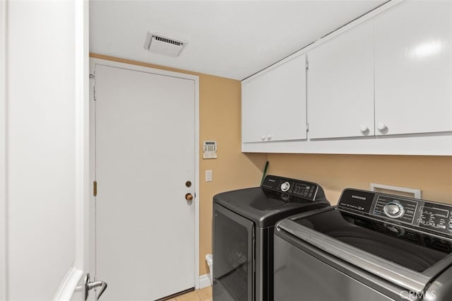 laundry area featuring cabinet space, visible vents, and washer and dryer