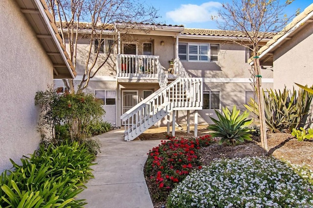 property entrance with a tile roof and stucco siding