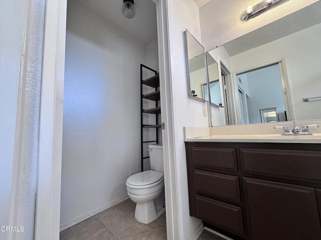 bathroom featuring baseboards, vanity, and toilet