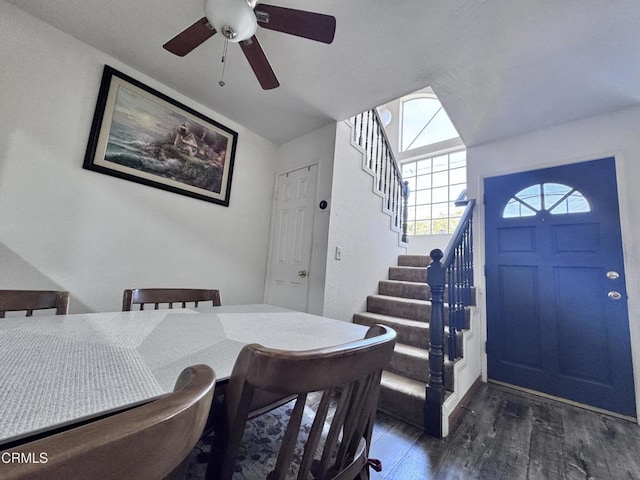 dining area featuring dark wood finished floors and stairs