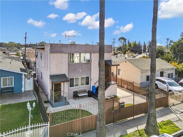 view of front of property with a fenced front yard, a residential view, and stucco siding