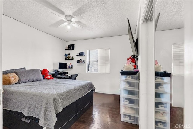 bedroom featuring a textured ceiling, dark wood-style flooring, and a ceiling fan